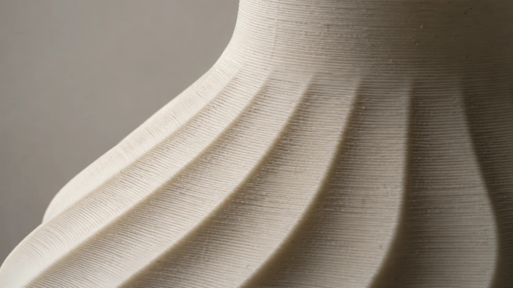 A close view of the horizontal print layers and curved surface of an ivory object.