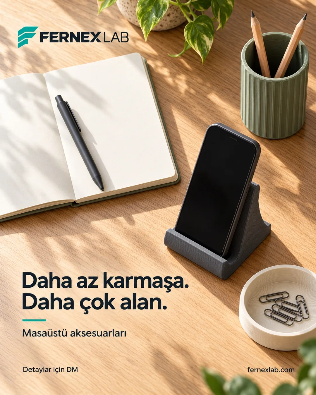 Ahşap masada grafit telefon standı, yeşil kalemlik ve krem tepsi; “Daha az karmaşa. Daha çok alan.”